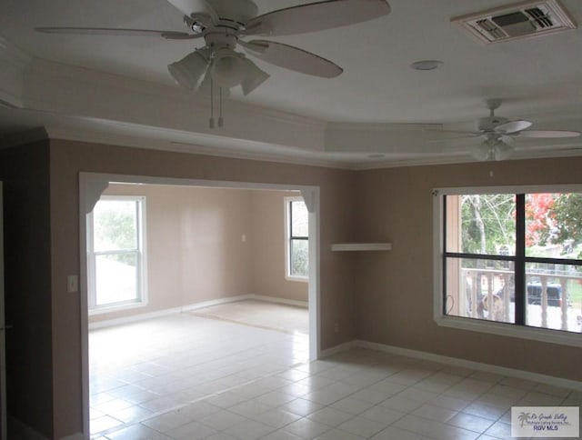 spare room featuring visible vents, baseboards, ornamental molding, light tile patterned flooring, and a raised ceiling