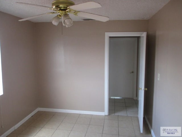 unfurnished room with light tile patterned floors, baseboards, a textured ceiling, and ceiling fan