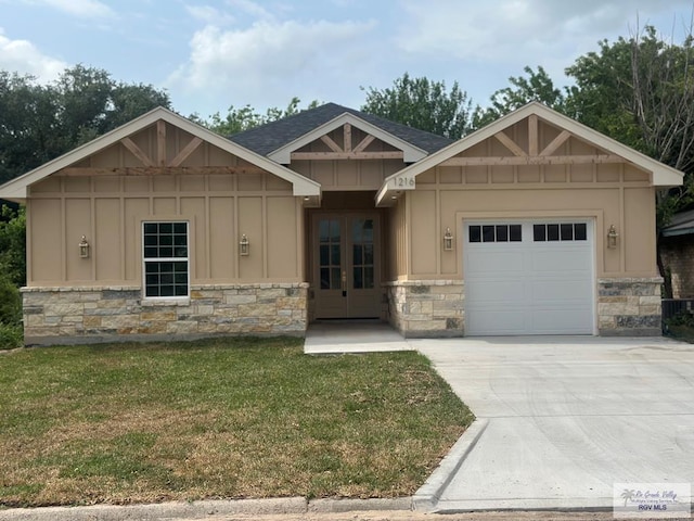 craftsman house with board and batten siding, stone siding, french doors, and an attached garage
