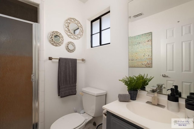 full bathroom featuring toilet, vanity, a shower stall, and visible vents