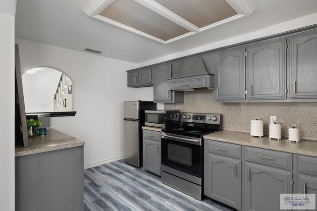 kitchen with stainless steel appliances, gray cabinets, custom range hood, and visible vents