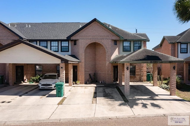 view of front of house featuring brick siding and roof with shingles