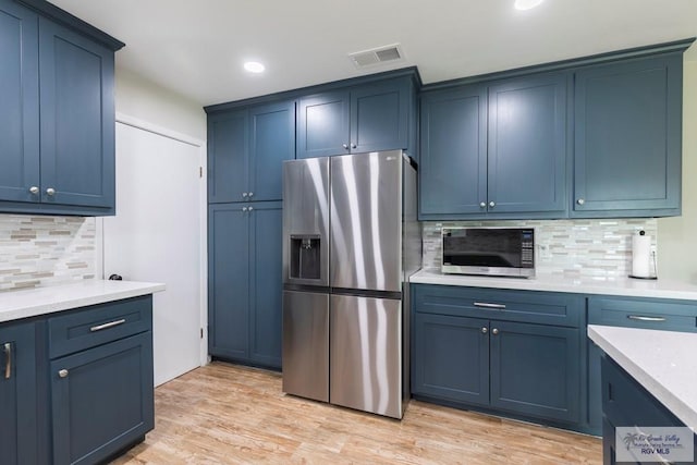 1409 Pine Ct, Harlingen, TX 78550 - kitchen with stainless steel appliances, tasteful backsplash, blue cabinets, light wood-type flooring, and recessed lighting