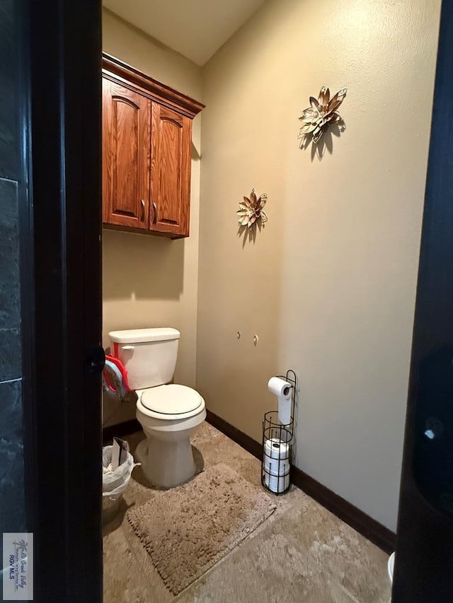 bathroom featuring toilet and baseboards