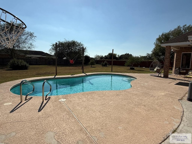 view of swimming pool with a yard and a patio