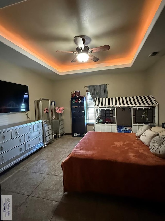 bedroom featuring visible vents, ceiling fan, and a tray ceiling