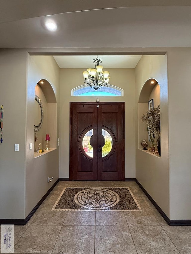 foyer with a notable chandelier and baseboards