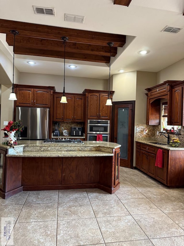 kitchen featuring tasteful backsplash, light stone counters, hanging light fixtures, and stainless steel appliances