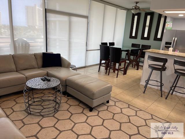 1000 Padre Blvd Unit 307, South Padre Island, TX 78597 - living room featuring a ceiling fan and light tile patterned flooring