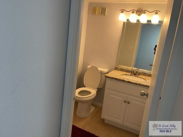 1000 Padre Blvd Unit 307, South Padre Island, TX 78597 - bathroom featuring tile patterned flooring, toilet, vanity, and a textured wall