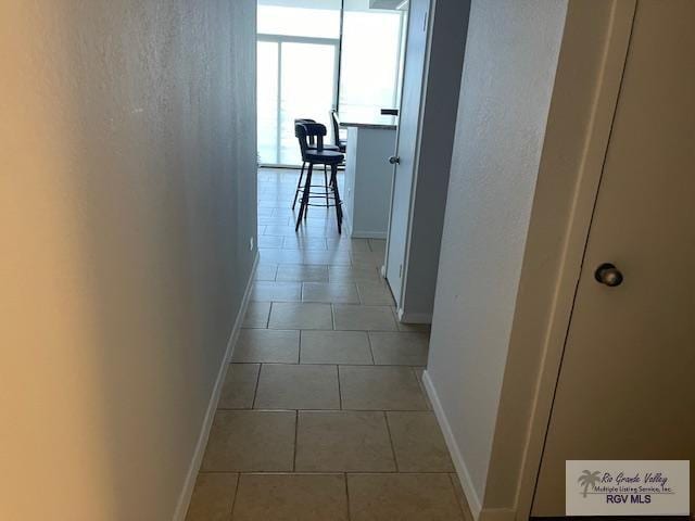 1000 Padre Blvd Unit 307, South Padre Island, TX 78597 - hallway featuring baseboards and light tile patterned floors