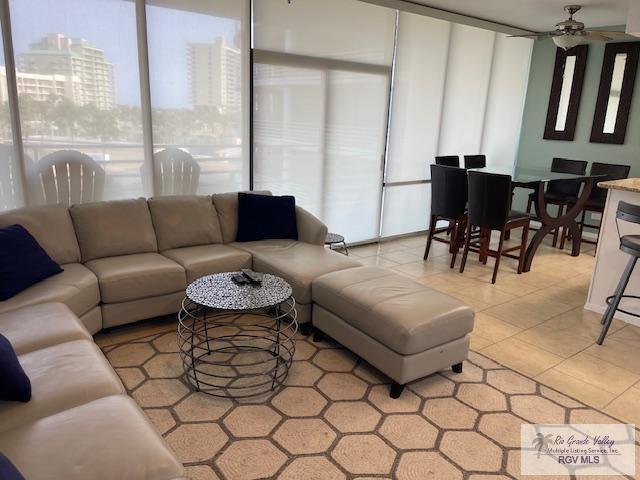 1000 Padre Blvd Unit 307, South Padre Island, TX 78597 - living area with light tile patterned floors, ceiling fan, and a view of city