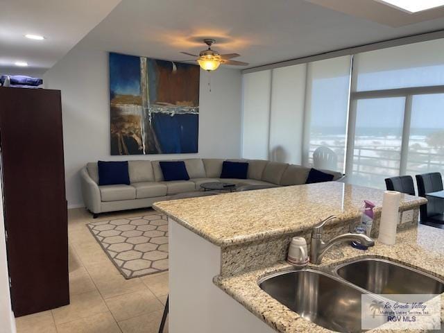 1000 Padre Blvd Unit 307, South Padre Island, TX 78597 - kitchen with a sink, light tile patterned flooring, light stone countertops, and ceiling fan