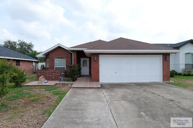 487 Agua Viva Ln, Brownsville, TX 78521 - single story home featuring brick siding, concrete driveway, a garage, and roof with shingles