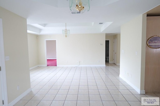 487 Agua Viva Ln, Brownsville, TX 78521 - empty room with a raised ceiling, light tile patterned floors, a chandelier, and baseboards