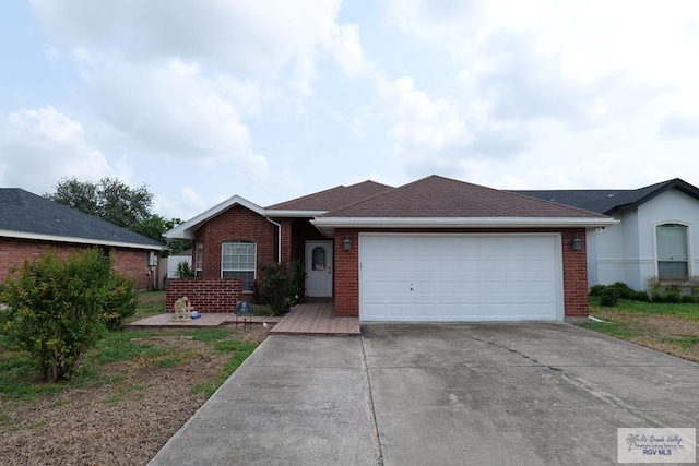 487 Agua Viva Ln, Brownsville, TX 78521 - ranch-style house with concrete driveway, brick siding, a garage, and a shingled roof