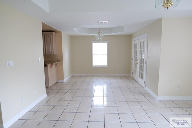 487 Agua Viva Ln, Brownsville, TX 78521 - spare room featuring a tray ceiling, light tile patterned floors, baseboards, and french doors
