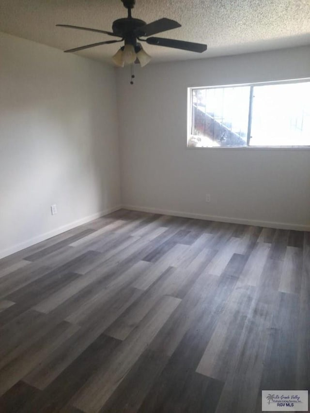 empty room featuring dark wood-style floors, ceiling fan, a textured ceiling, and baseboards