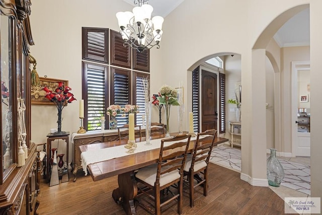 dining room featuring hardwood / wood-style flooring, ornamental molding, and an inviting chandelier