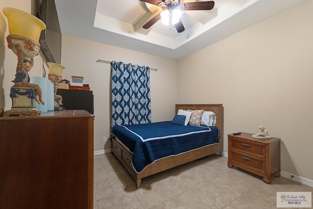 tiled bedroom with a raised ceiling and ceiling fan