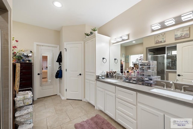 bathroom featuring tile patterned flooring, vanity, and a shower with door