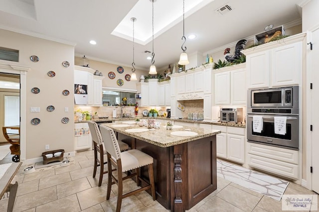 kitchen featuring light stone countertops, white cabinetry, a center island, and stainless steel appliances