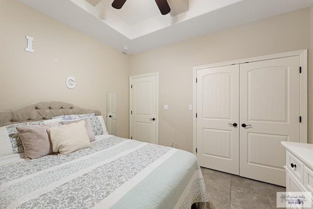 tiled bedroom with ceiling fan and a closet