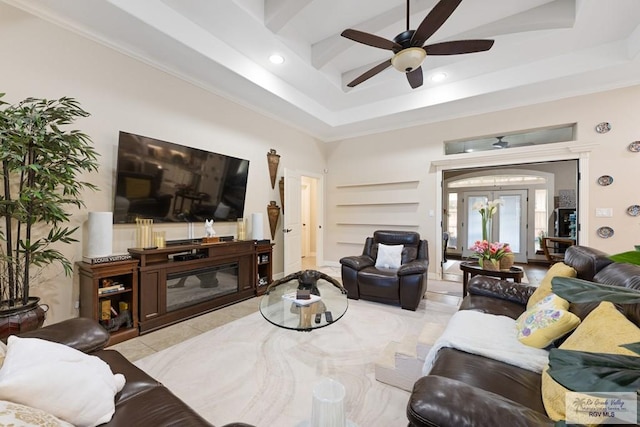 tiled living room featuring a tray ceiling, ceiling fan, and ornamental molding