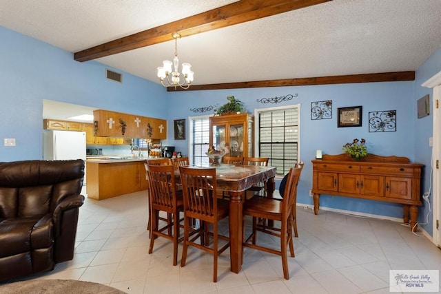 dining room with sink, a textured ceiling, lofted ceiling with beams, and an inviting chandelier