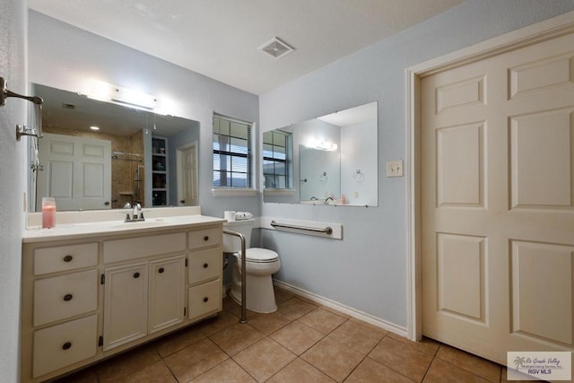 bathroom featuring toilet, tile patterned floors, and vanity