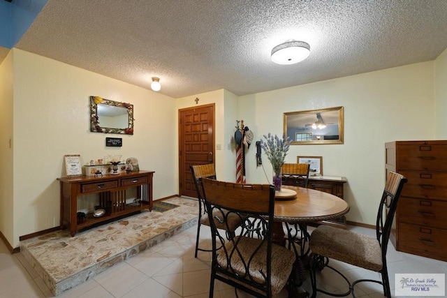 tiled dining room with a textured ceiling