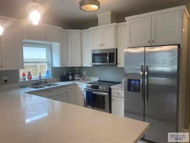 kitchen with appliances with stainless steel finishes, light stone countertops, white cabinets, and a sink