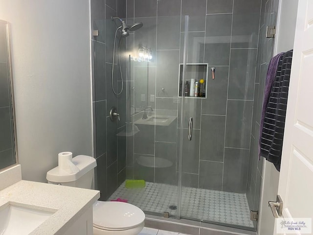 bathroom featuring a stall shower, toilet, and vanity
