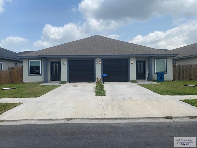 ranch-style house featuring a garage, fence, and a front yard