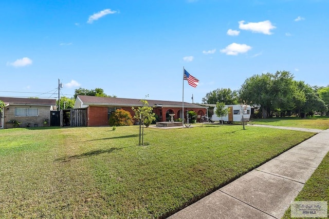 ranch-style house featuring a front yard and brick siding