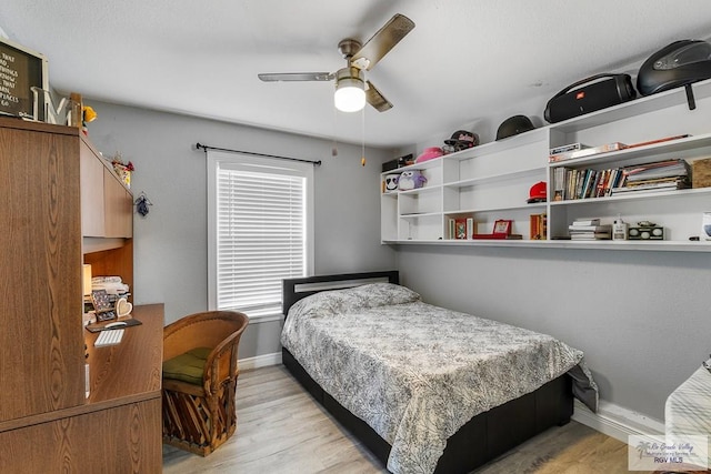 bedroom with ceiling fan, light wood-style flooring, and baseboards