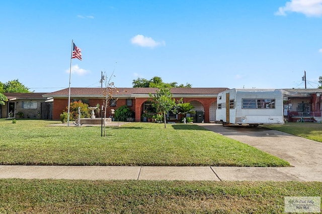 ranch-style house with a front yard, brick siding, and driveway