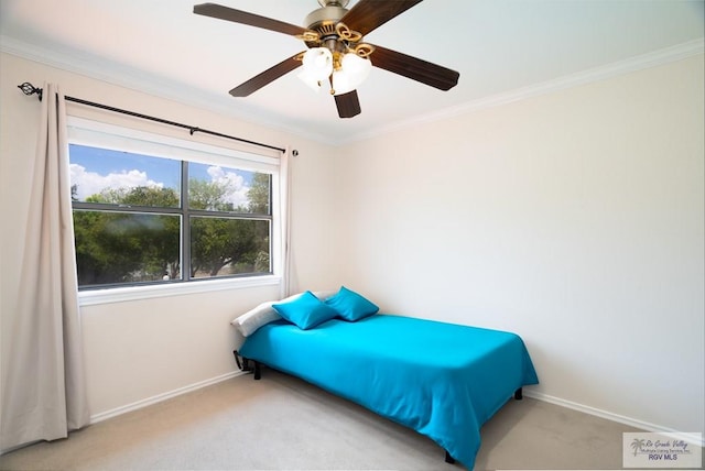 carpeted bedroom with ceiling fan and ornamental molding