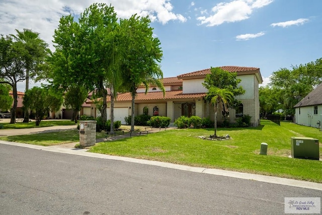 mediterranean / spanish-style home featuring a front lawn and a garage