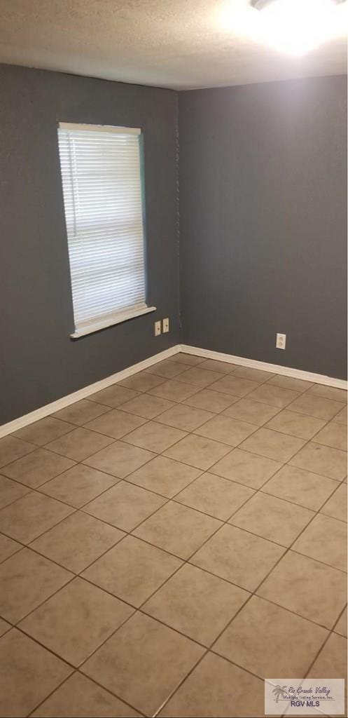 unfurnished room featuring baseboards and a textured ceiling