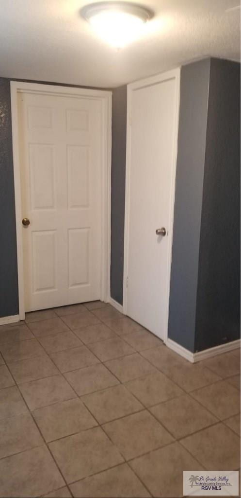 interior space with baseboards and light tile patterned floors