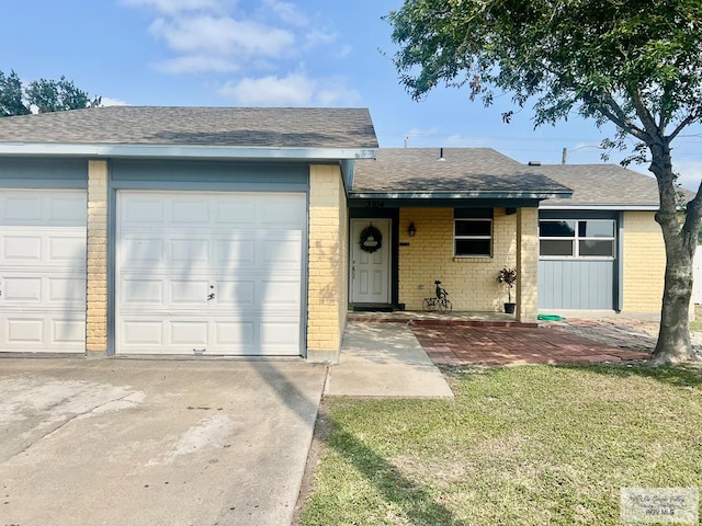 3104 Buckingham Ct, Brownsville, TX 78526 - ranch-style house with brick siding, driveway, a shingled roof, a front lawn, and an attached garage