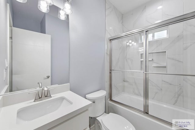 full bathroom with vanity, toilet, and shower / bath combination with glass door