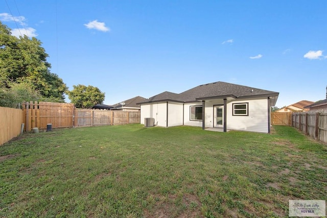 rear view of house with a yard and central air condition unit