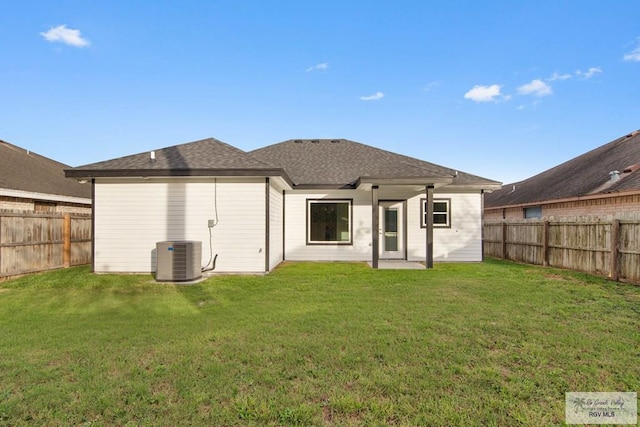 rear view of property featuring a yard and central AC