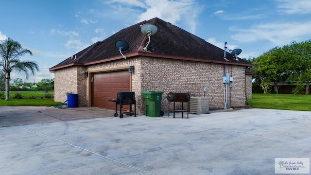 view of side of property with a garage and central air condition unit