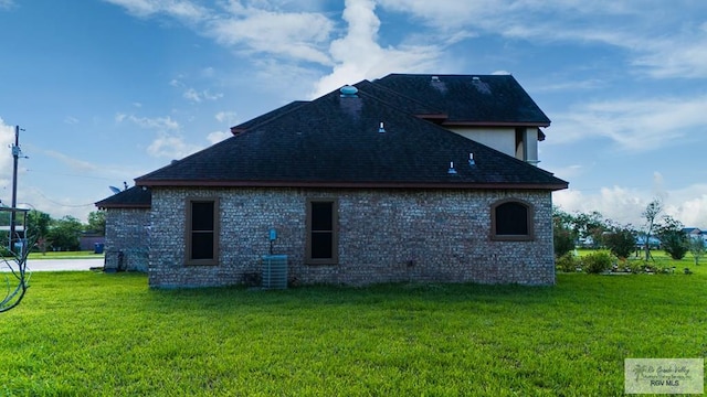 view of home's exterior featuring central AC unit and a yard