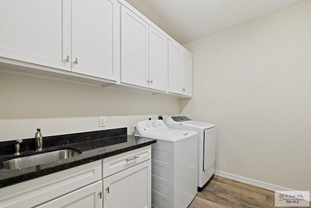 clothes washing area with cabinets, independent washer and dryer, dark hardwood / wood-style floors, and sink