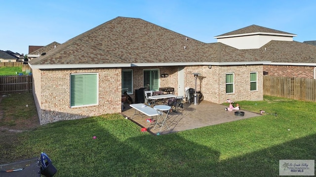 rear view of house featuring a lawn and a patio area