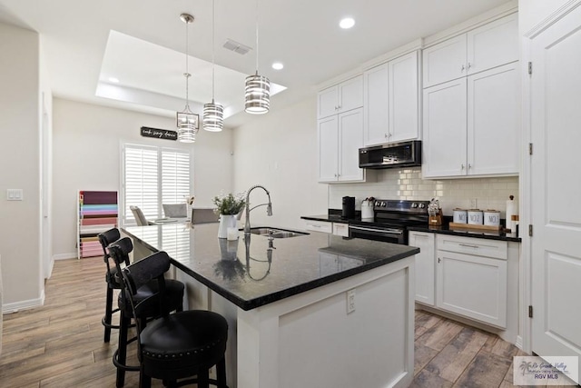 kitchen featuring a center island with sink, white cabinetry, sink, and appliances with stainless steel finishes